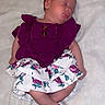 adorable, baby, blanket, child, closed_eyes, cute, floral_skirt, heart_shapes, indoors, infant, lying_down, newborn, peaceful, portrait, purple_clothing, resting, skin, sleeping, soft_texture, tiny_feet