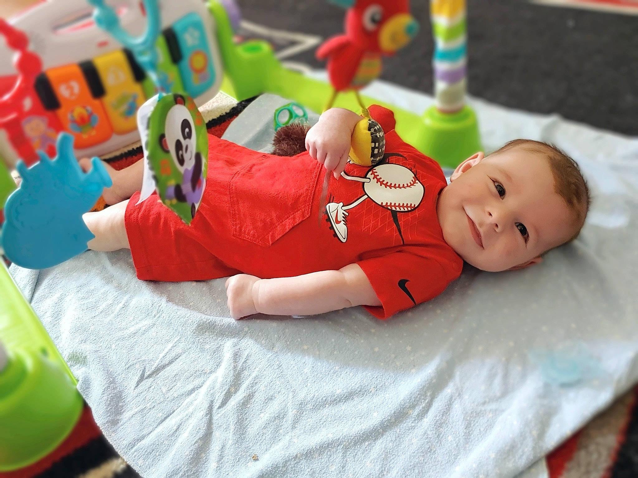 Dalton joined the competition — help win amazing prizes! baby, baby_playing_with_toys, baby_products, baby_toddler_clothing, comfort, event, fun, green, happy, human_body, joy, leg, leisure, linens, person, red, room, sitting, smile, textile