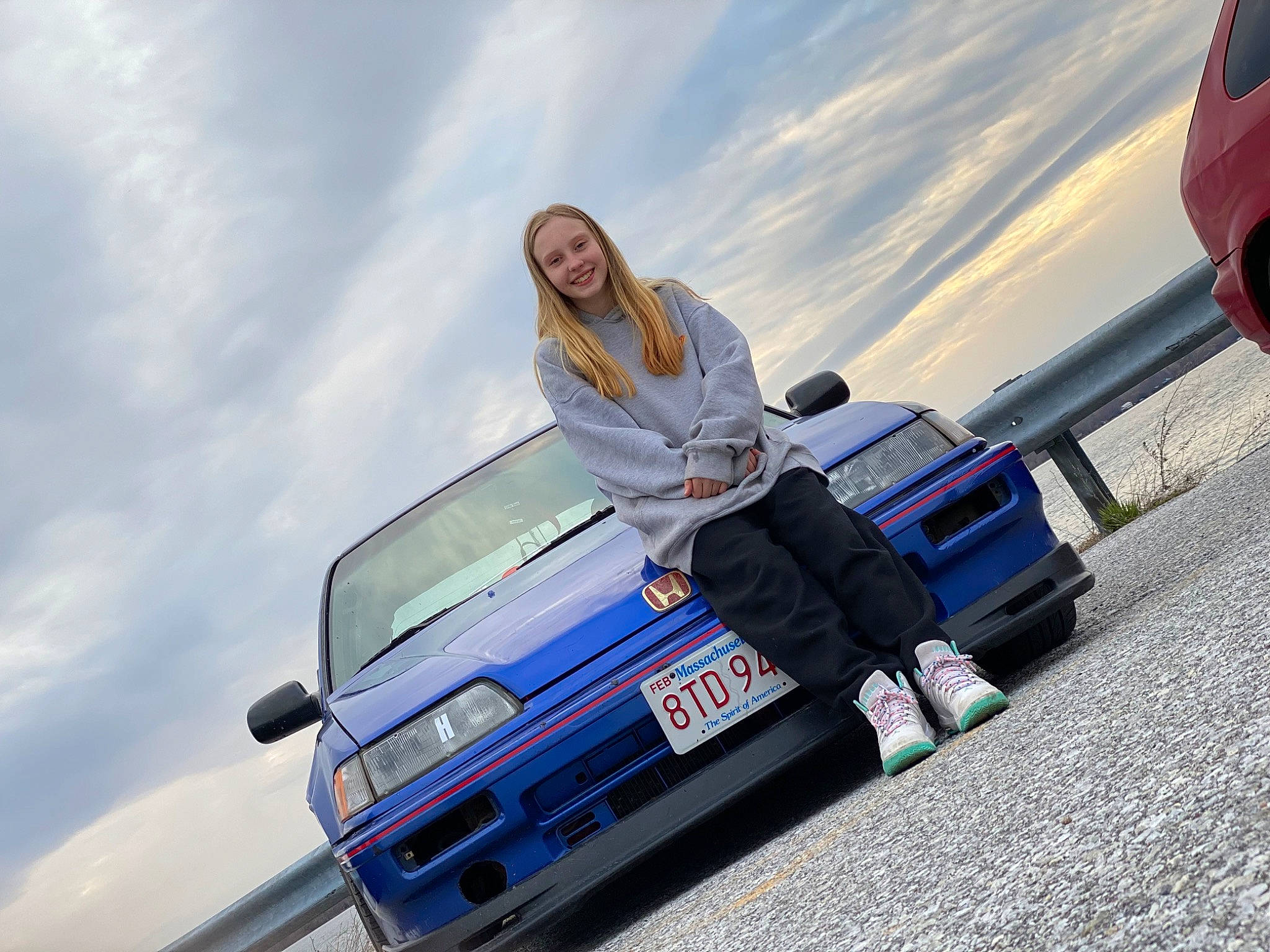 Skylynn is registered to the contest to win money with this photo: asphalt, automotive_design, automotive_exterior, automotive_tire, bumper, car, cloud, electric_blue, hood, joy, motor_vehicle, person, personal_luxury_car, rim, rolling, sky, smile, tire, travel, vehicle