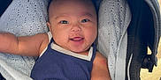 Mikaela is registered to the contest to win money with this photo: baby, car_seat, blanket, bottle, smile, infant, child, clothing, seatbelt, happy, indoors, person, cute, comfort, sitting, baby_toy, fabric, portrait, nappy, head
