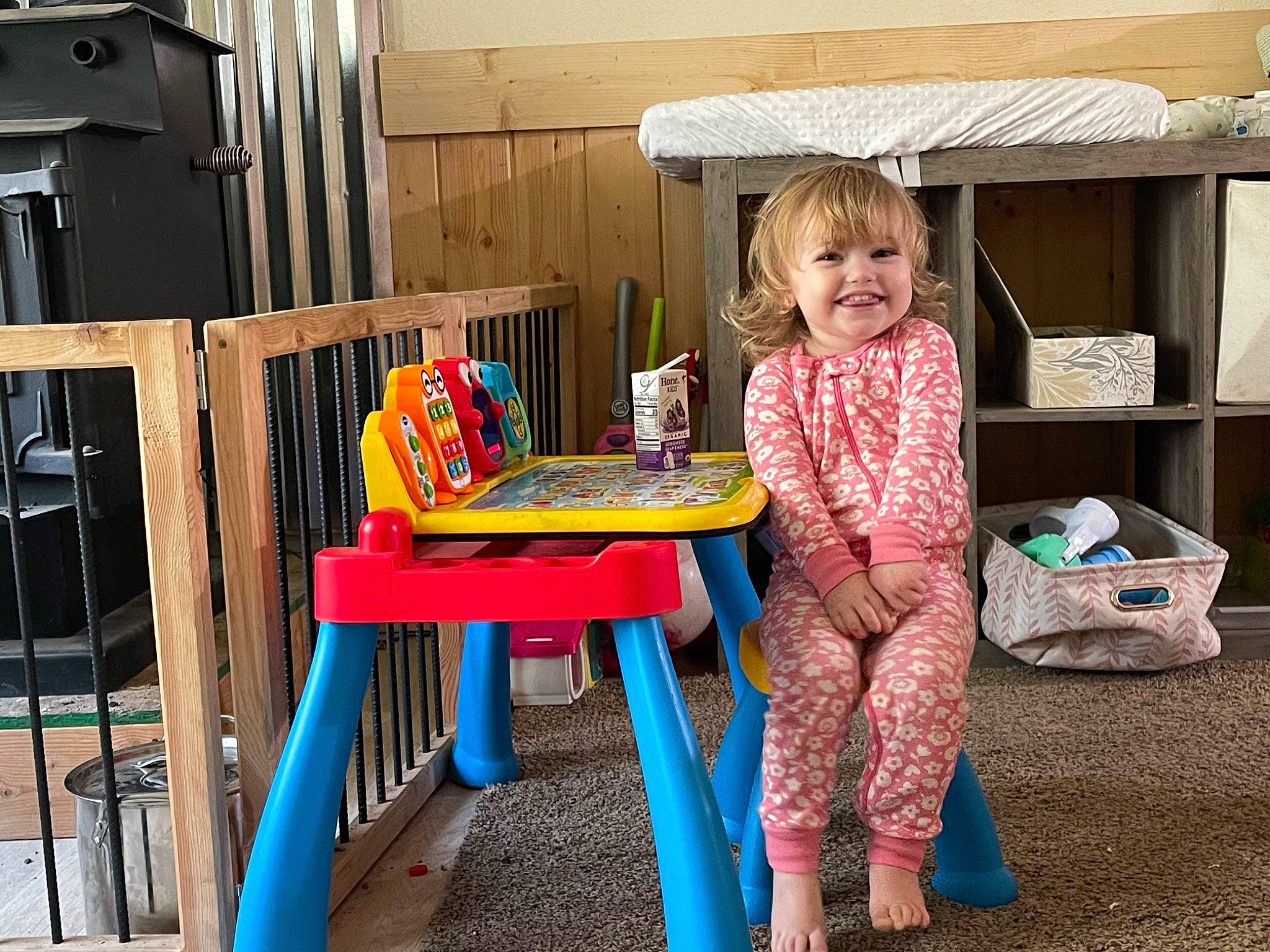 Clara Mae is registered to the contest to win money with this photo: box, chair, child, fun, furniture, joy, leisure, magenta, outdoor_furniture, outdoor_table, person, play, room, sharing, sitting, smile, standing, table, toddler, vacation