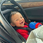 Ezekiah joined the competition — help win amazing prizes! baby, car_seat, smiling, child, car_interior, seatbelt, red_clothing, toy, sippy_cup, happy, infant, window, sunlight, transportation, seat, safety, cheerful, person, young_child, casual