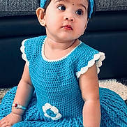 Edhaa is registered to the contest to win money with this photo: baby, child, girl, blue_dress, headband, crocheted_clothing, bracelets, indoor, carpet, cute, portrait, sitting, young_child, earrings, curious_expression, fashion, accessories, face, person, toddler