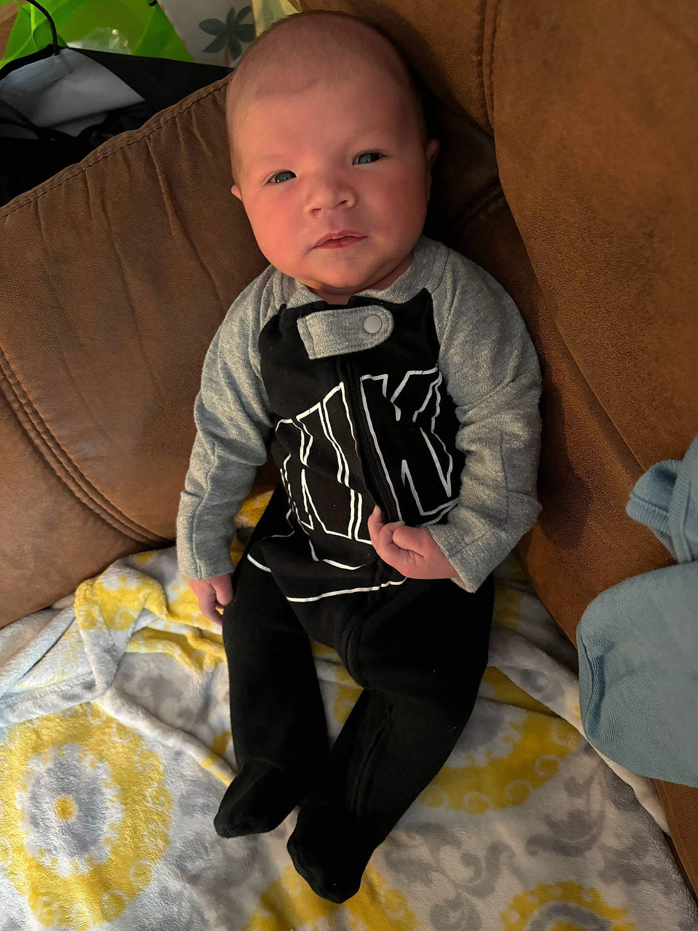 Brayden is registered to the contest to win money with this photo: baby, bodypart, clothing, couch, cushion, face, finger, furniture, hand, head, homedecor, jeans, knitwear, pants, person, photography, portrait, sitting, sweater, t_shirt