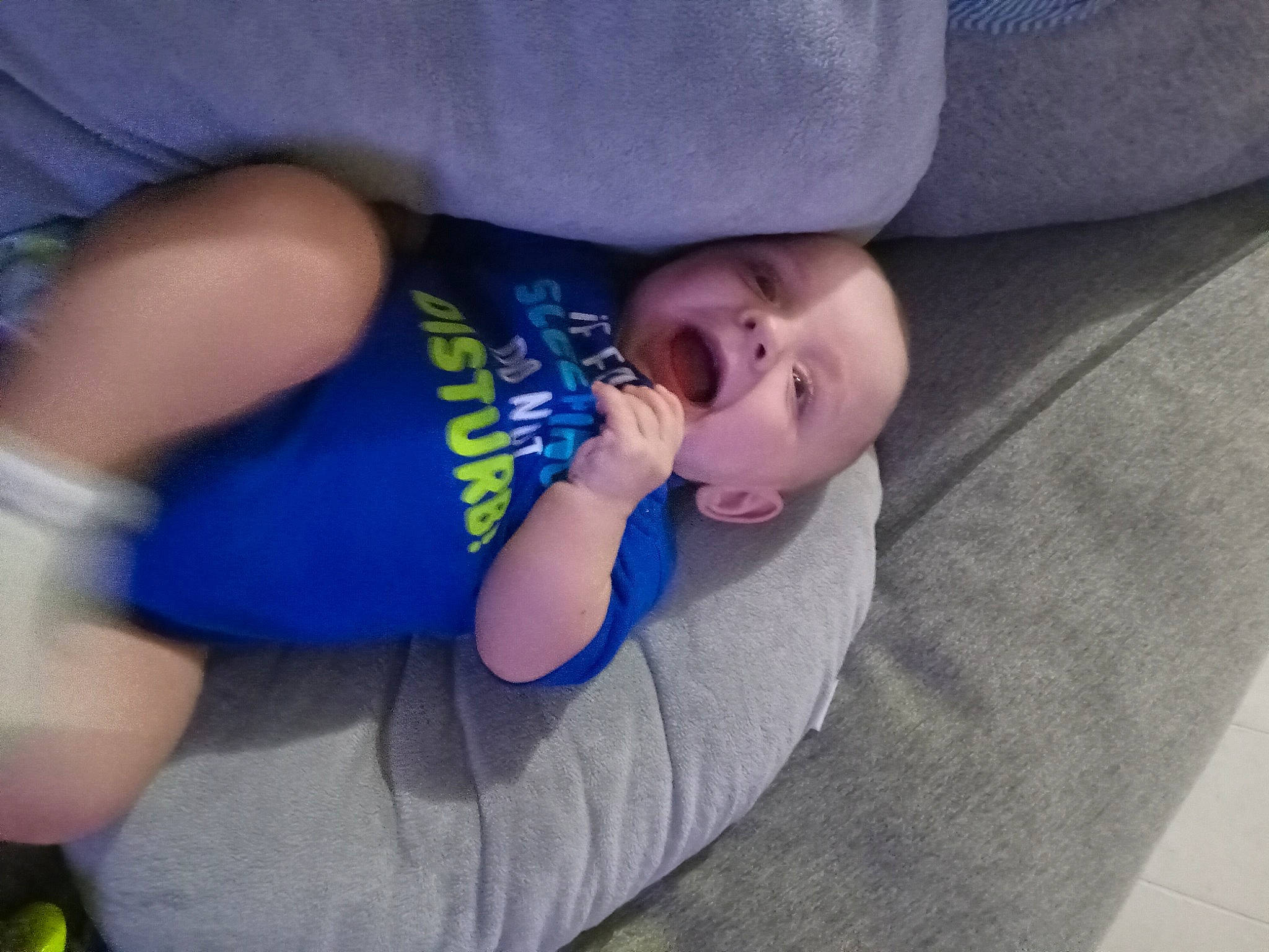 Mark is registered to the contest to win money with this photo: baby, baby_products, baby_toddler_clothing, cheek, child, comfort, elbow, electric_blue, eye, finger, foot, human_leg, linens, nail, person, sitting, thigh, thumb, toddler, tree