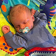 Jacob joined the competition — help win amazing prizes! baby, pacifier, sleeping, blue_clothing, play_mat, colorful, toy, infant, child, cute, peaceful, soft_toys, fabric, pattern, indoors, young_child, resting, hand, head, face