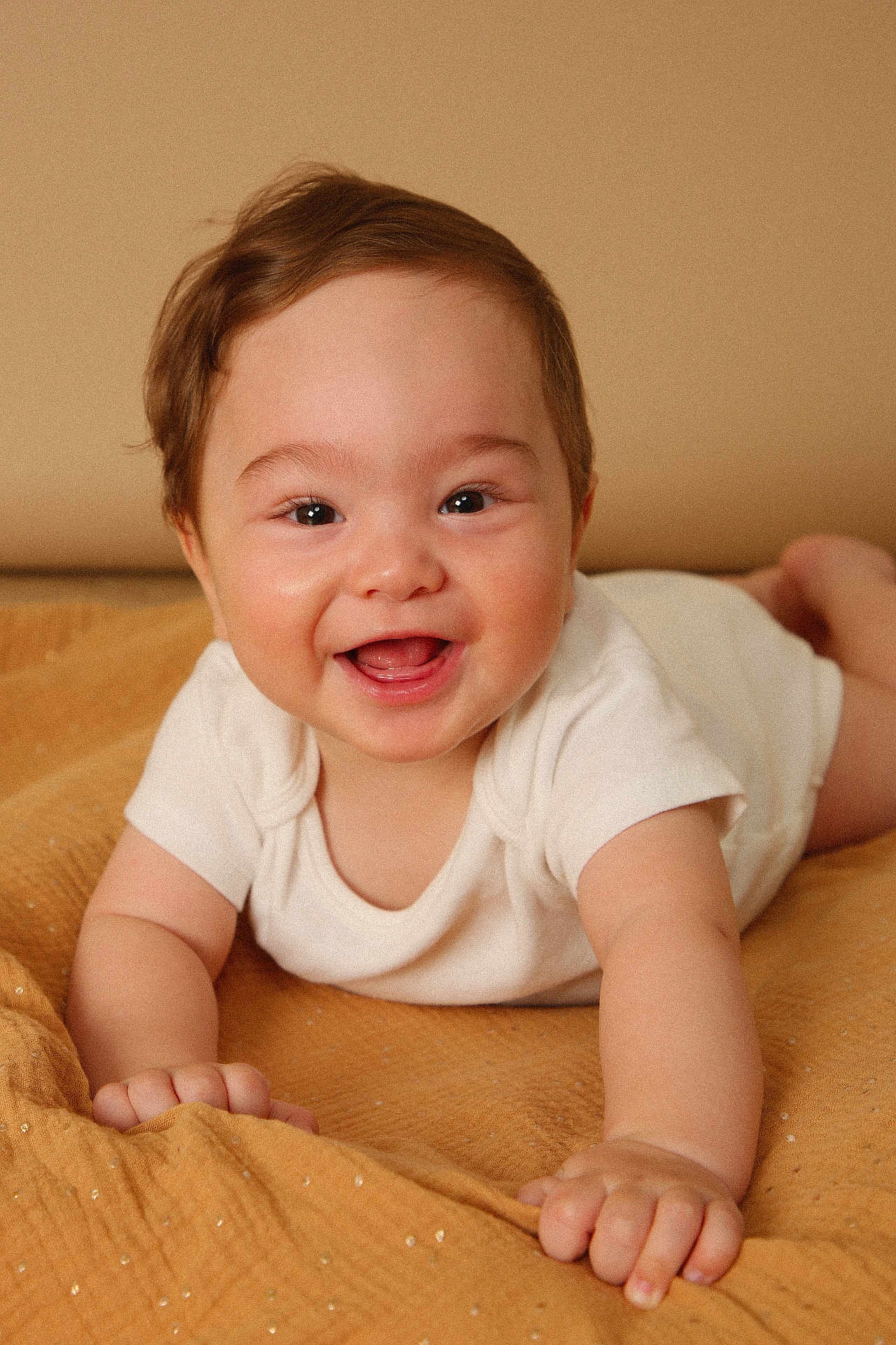 Tino a rejoint le concours — aidez-le/la à gagner de superbes lots ! baby, smiling, infant, white_clothing, blanket, lying_down, happy, cute, child, face, skin, hand, indoors, young, portrait, expression, toddler, warm_tones, closeup, soft_lighting