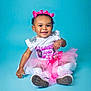 Brooklyn joined the competition — help win amazing prizes! toddler, child, smiling, pink_bow, tutu, white_shirt, sitting, cute, portrait, studio, blue_background, happy, fashion, young_child, footwear, accessory, bracelet, earrings, playful, innocent