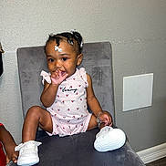 Brooklyn joined the competition — help win amazing prizes! toddler, child, sitting, thumb_sucking, braided_hair, white_beads, pink_outfit, white_shoes, gray_chair, indoor, wall, panel, hand, cute, young_child, person, portrait, footwear, fashion, accessory