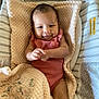 baby, infant, blanket, baby_seat, smiling, pink_clothing, face, soft_texture, cute, comfortable, indoor, portrait, child, person, closeup, resting, fabric, head, baby_girl, cozy