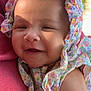 baby, infant, smiling, face, headwear, floral_pattern, bonnet, arm, person, outdoor, sunlight, closeup, happy, cute, child, skin, nature, fabric, holding, portrait