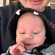 Everett is registered to the contest to win money with this photo: baby, child, person, smile, hoodie, clothing, hand, face, adult, closeup, portrait, indoor, skin, button, expression, cute, newborn, holding, casual, warm