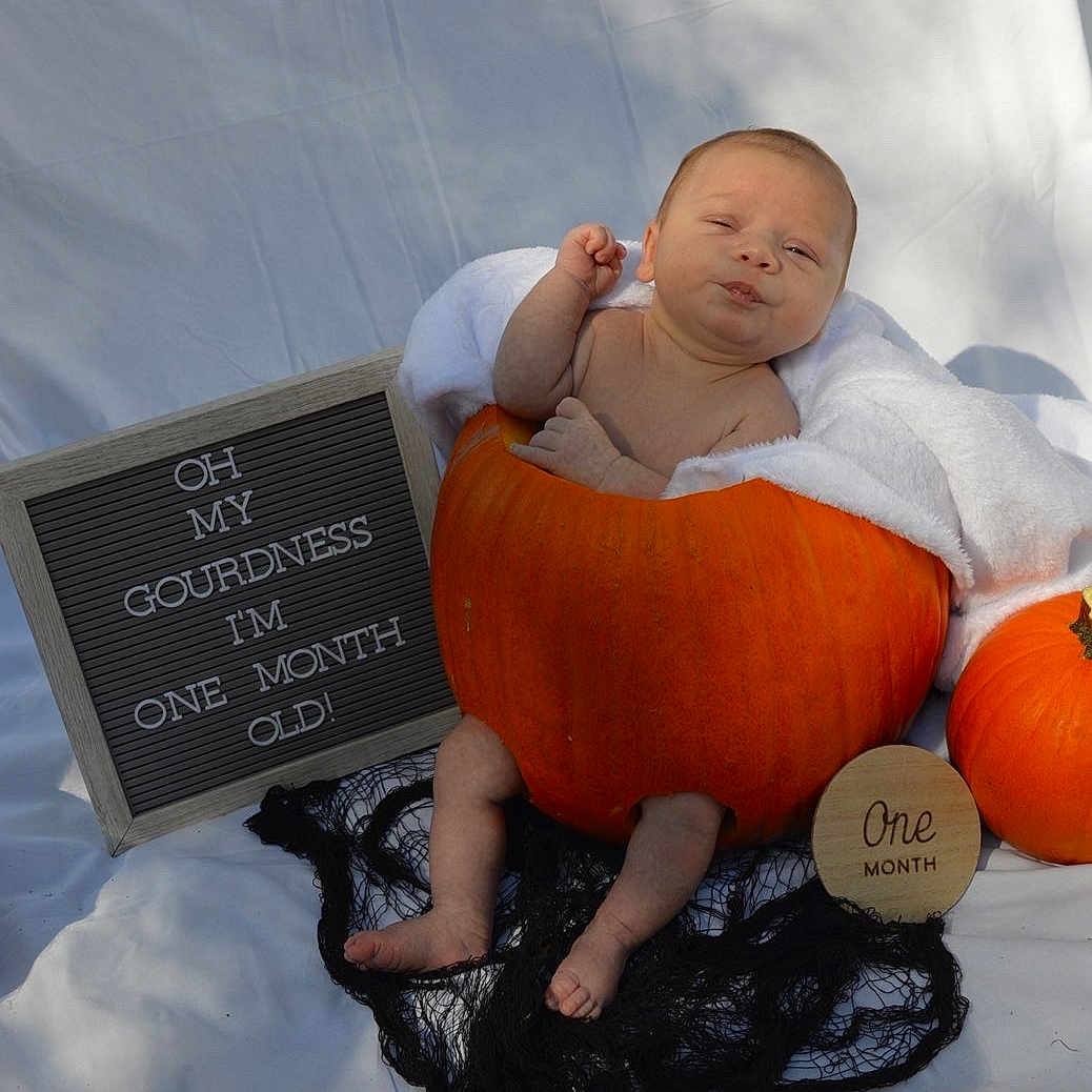 Everett is registered to the contest to win money with this photo: autumn, baby, black_netting, cute, expression, feet, head, holiday, infant, letter_board, newborn, one_month, outdoor, portrait, pumpkin, sign, skin, towel, white_fabric, wrapped