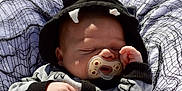 Everett joined the competition — help win amazing prizes! baby, pacifier, sleeping, hood, black_hood, white_horns, hand, blanket, net, infant, clothing, cute, resting, face, peaceful, toddler, child, soft_light, portrait, closeup