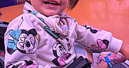 Leilanny is registered to the contest to win money with this photo: casual, child, clothing, cute, face, footwear, happy, hoodie, indoor, joy, minnie_mouse, orange_floor, person, pigtails, playful, seated, smiling, stroller, toddler, young_child