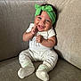 baby, baby_clothes, beige, child, couch, cozy, cute, furniture, green_headband, happy, headwear, hearts_pattern, indoors, infant, person, portrait, sitting, smile, sock, white_outfit