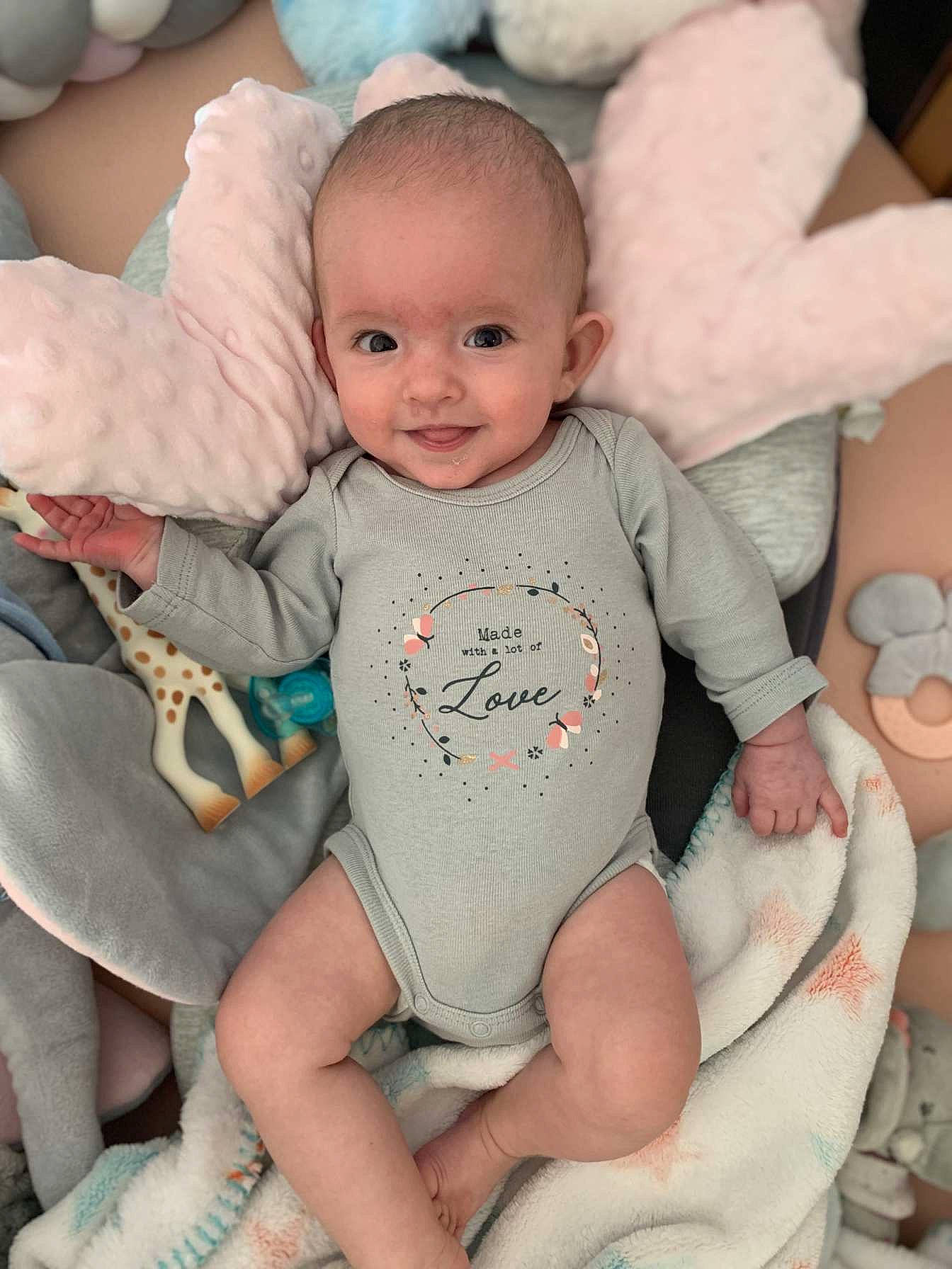 Ana participe au concours pour gagner de l'argent avec cette photo : arm, baby, baby_toddler_clothing, cheek, chin, eye, face, head, human_body, joy, leg, lip, mouth, organ, person, photograph, skin, sleeve, smile, stomach