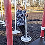 Bryson joined the competition — help win amazing prizes! child, playground, pole, jacket, camo, platform, chains, red_pole, outdoor, park, trees, bare_trees, grass, daylight, black_rubber_mulch, shoes, pants, holding, balance, young