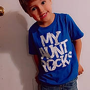 Bryson joined the competition — help win amazing prizes! blue_tshirt, boy, casual_clothing, child, cute, denim_shorts, door, expression, happy, indoor, light_skin, person, playful, portrait, shadow, short_hair, smiling, standing, text_on_clothing, young