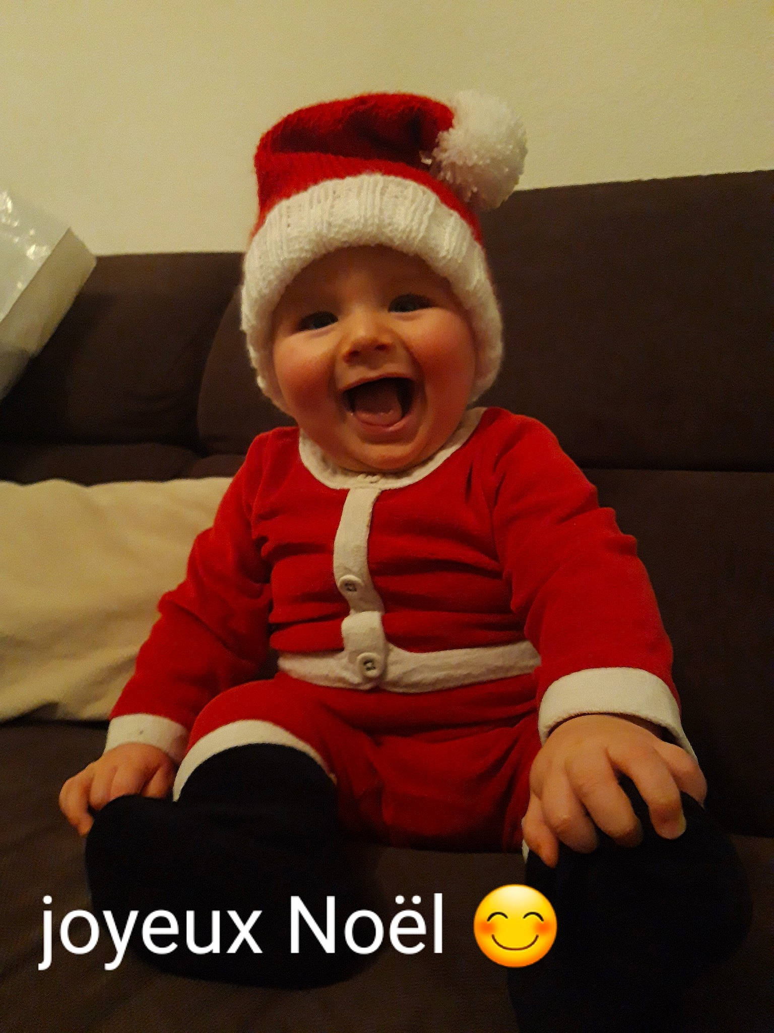 Hugo a rejoint le concours — aidez-le/la à gagner de superbes lots ! baby, baby_toddler_clothing, cap, comfort, costume_hat, event, eye, facial_expression, fictional_character, finger, happy, hat, headwear, human_body, lap, person, product, santa_claus, sitting, sleeve