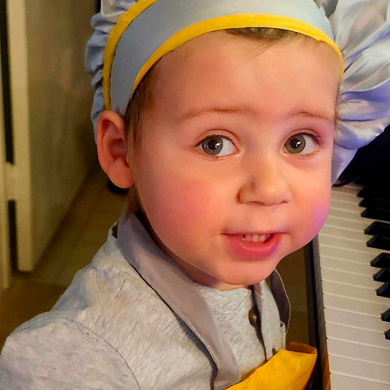Ian is registered to the contest to win money with this photo: toddler, child, chef_hat, apron, piano, indoor, curious, face, person, clothing, young_child, headwear, music, kitchen, portrait, expression, playing, cute, smiling, baby