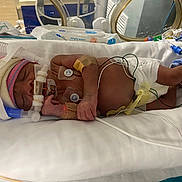 Hinata is registered to the contest to win money with this photo: architecture, baby, bed, building, clinic, clothing, crib, doctor, face, furniture, glove, head, hospital, indoors, infantbed, medicalprocedure, newborn, operatingtheatre, person, photography