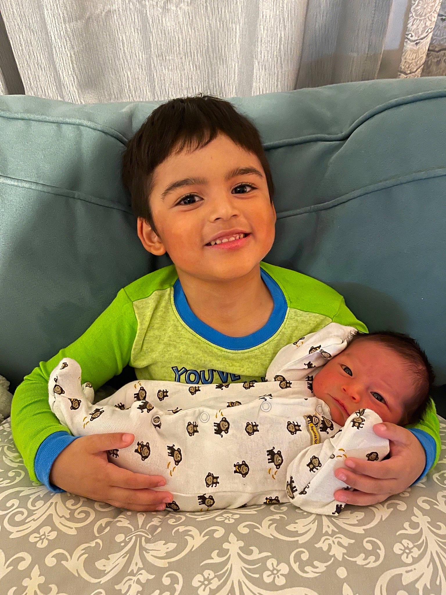 Gianni is registered to the contest to win money with this photo: baby, baby_toddler_clothing, cheek, child, comfort, couch, eye, hairstyle, happy, head, joy, leg, linens, person, product, skin, sleeve, smile, t_shirt, textile