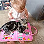 Lucy Cat joined the competition — help win amazing prizes! toddler, child, cat, tabby_cat, pink_mat, floor, kitchen, tiles, barefoot, hair_ties, curly_hair, sitting, pet, indoor, refrigerator, colorful, cartoon, playful, cute, content