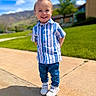child, boy, smiling, outdoor, sunny_day, blue_sky, clouds, grass, tree, mountains, sidewalk, shirt, jeans, sneakers, happy, portrait, casual_clothing, standing, hair, daylight