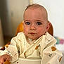 Ethan a rejoint le concours — aidez-le/la à gagner de superbes lots ! baby, child, high_chair, bib, cookie, food, messy_face, blue_eyes, cute, sitting, indoor, person, apparel, feeding, young_child, portrait, hand, table, expression, infant