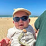baby, sunglasses, cap, beach, ocean, sky, person, child, happy, smiling, sunny, outdoor, clothing, pacifier, hand, holding, sand, summer, casual, portrait