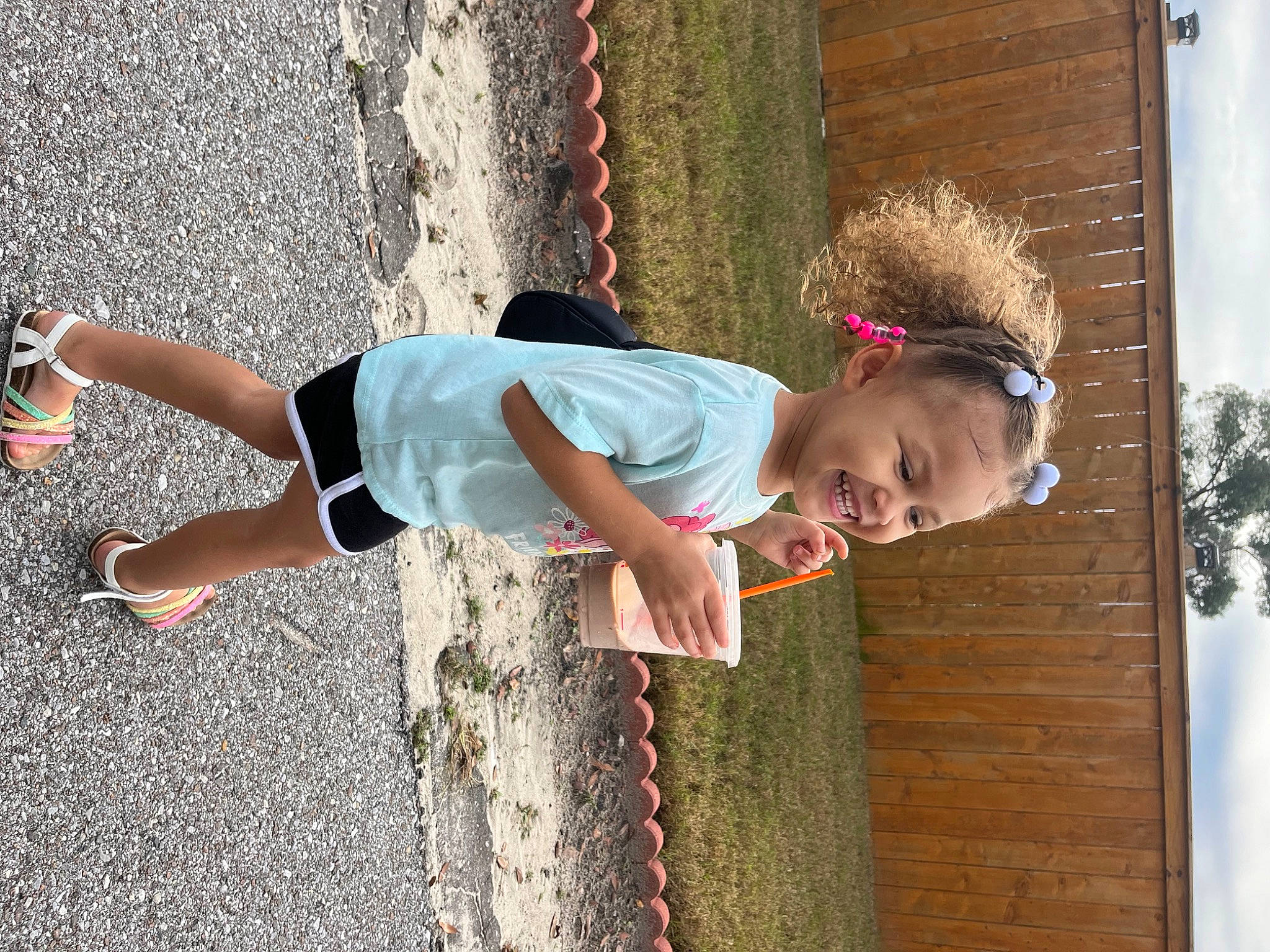 Armani is registered to the contest to win money with this photo: child, denim, eyewear, fun, grass, happy, human_leg, leisure, people_in_nature, person, recreation, shorts, sidewalk, sky, smile, sunglasses, t_shirt, toddler, tree, waist