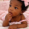 baby, child, infant, portrait, close_up, curly_hair, pink_bow, dress, smiling, curious, finger_in_mouth, sitting, blanket, teddy_bear, nursery, pink, cozy, indoors, soft_lighting, adorable