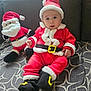 baby, santa_suit, plush_toy, stuffed_santa, red_clothing, white_fur_trim, black_belt, black_boots, hat, holiday, christmas, cute, child, indoor, couch, patterned_blanket, festive, smiling, portrait, infant