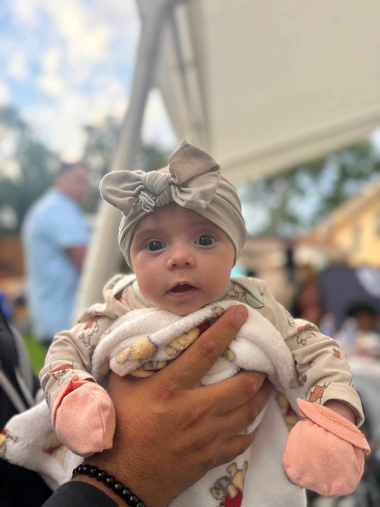 Victoria joined the competition — help win amazing prizes! baby, infant, headband, bow, mittens, hand, clothing, blanket, outdoor, person, face, portrait, cute, holding, soft_focus, daylight, expression, young_child, apparel, warm
