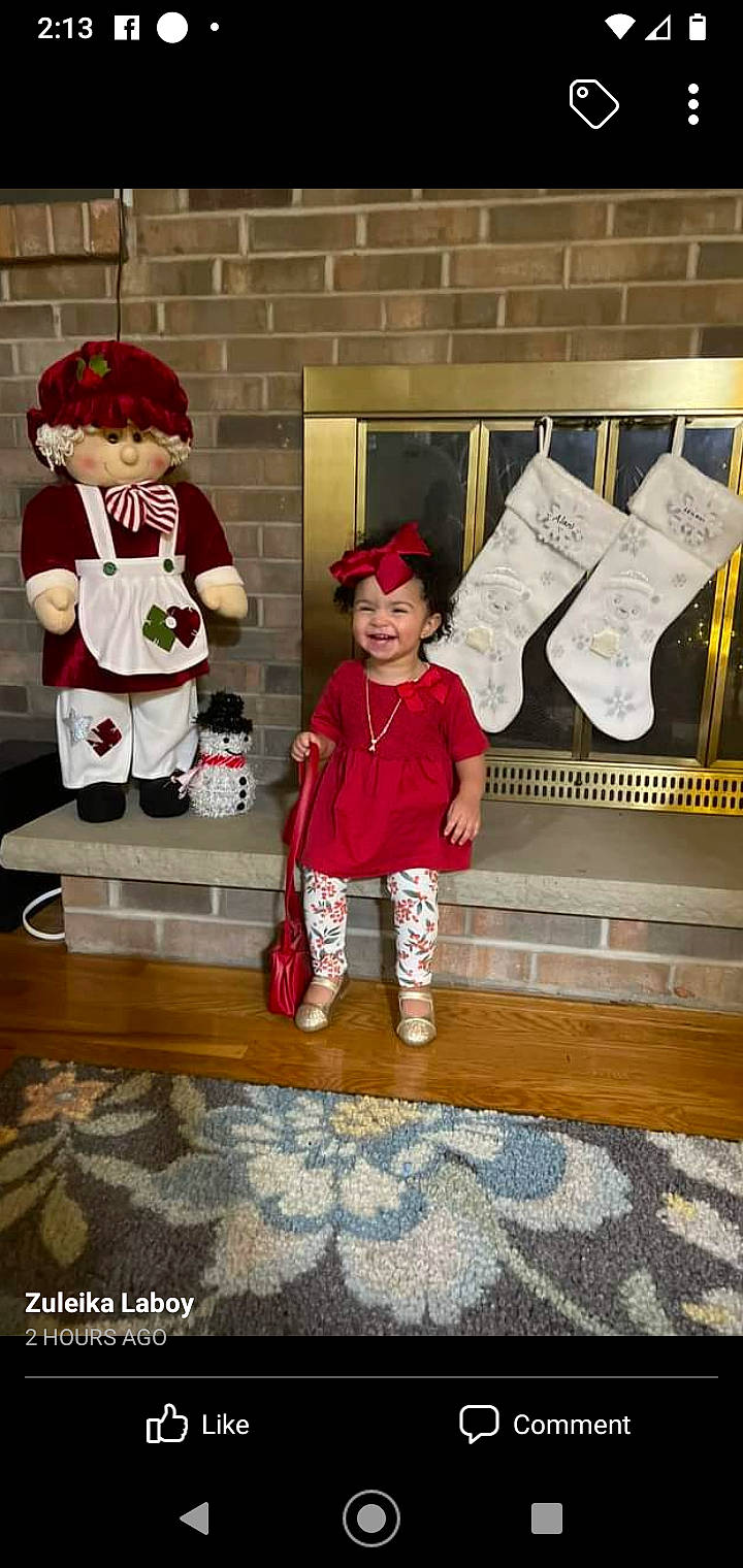 Alani is registered to the contest to win money with this photo: cap, carmine, child, fashion, flooring, fun, fur, hat, headwear, holiday, joy, lawn_ornament, person, room, santa_claus, sleeve, smile, standing, textile, toddler