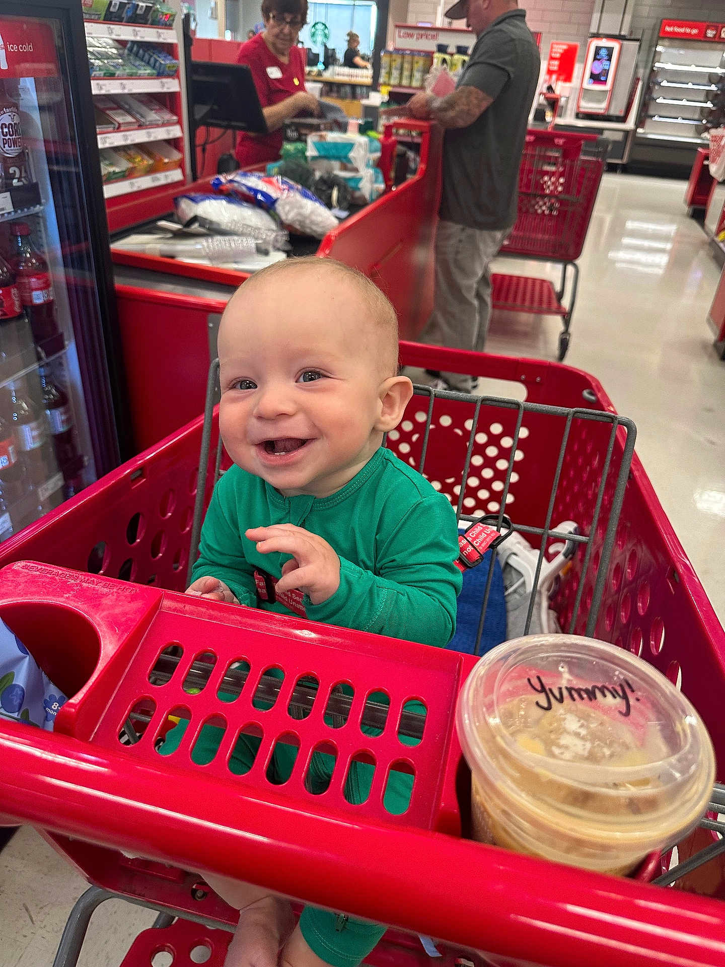 Banks joined the competition — help win amazing prizes! baby, shopping_cart, store, checkout, smiling, green_clothing, cup, lid, food, customer, cashier, retail, indoor, person, happy, shopping, floor, red, plastic, seat