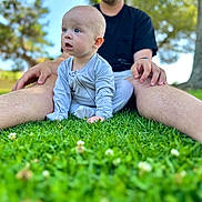 Banks joined the competition — help win amazing prizes! baby, adult, grass, outdoor, nature, tree, greenery, pajamas, sitting, child, person, legs, blurred_background, sunlight, casual, relaxed, glasses, male, portrait, daytime
