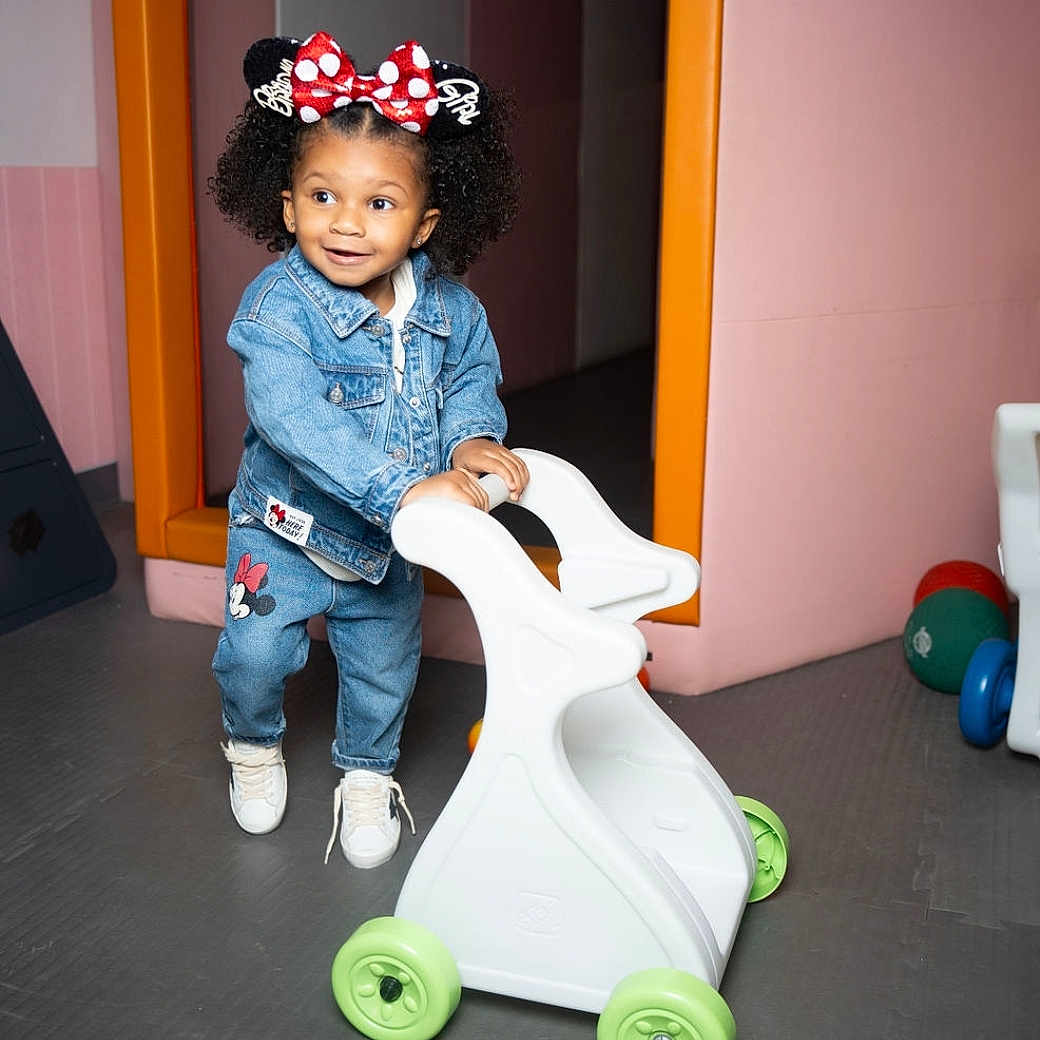 Amira joined the competition — help win amazing prizes! accessories, child, clothing, costume, face, female, footwear, girl, hat, head, indoors, jeans, machine, pants, person, photography, portrait, shoe, wheel, wood