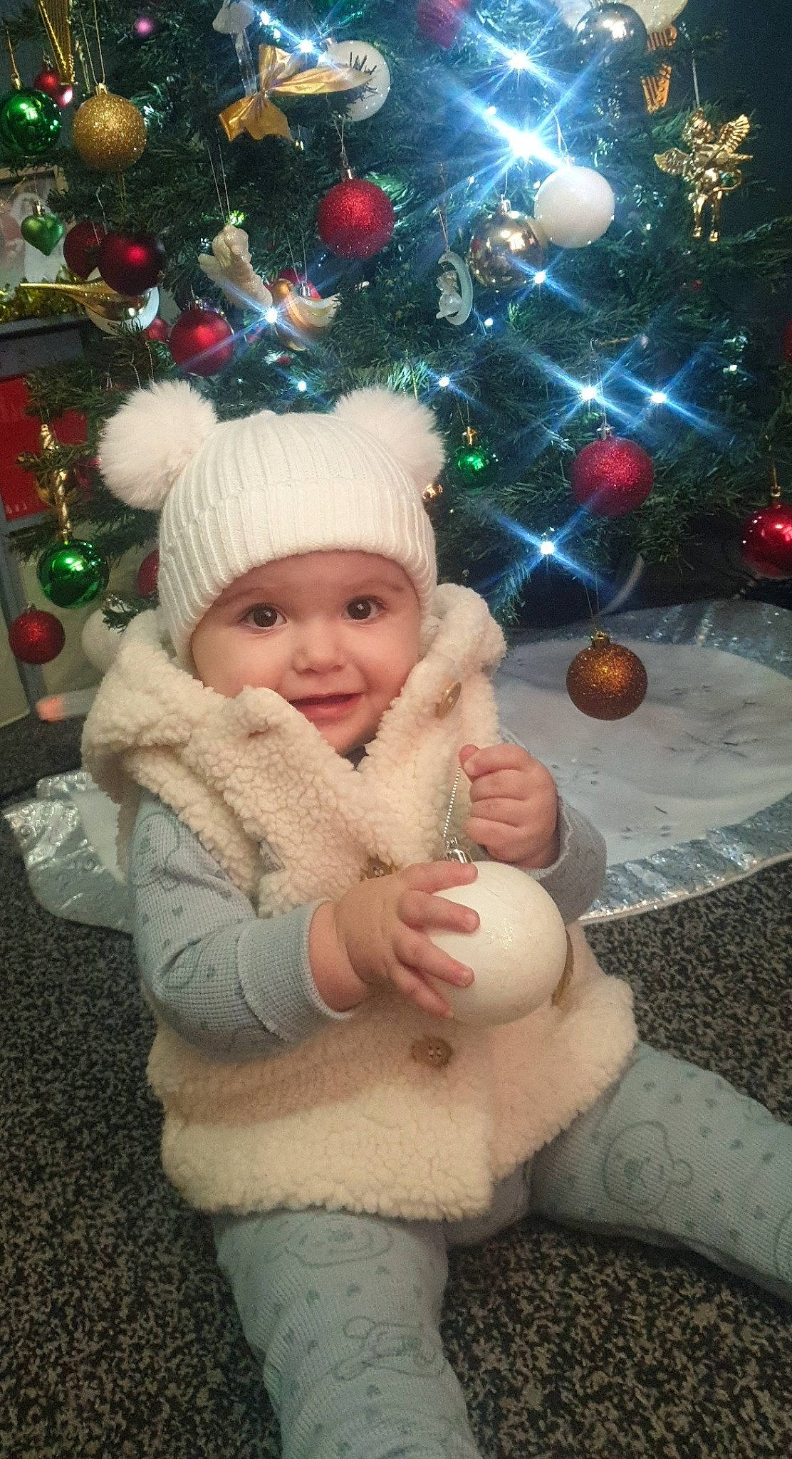 Winter-gray is registered to the contest to win money with this photo: christmas, christmas_decoration, christmas_ornament, christmas_tree, eye, face, facial_expression, fun, happy, head, headwear, holiday_ornament, human_body, ornament, person, photograph, plant, smile, standing, toddler