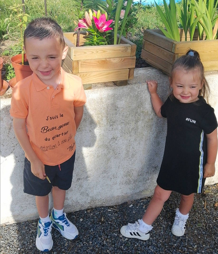 Chloé participe au concours pour gagner de l'argent avec cette photo : black, child, event, flower, flowerpot, fun, garden, grass, happy, joy, leisure, person, plant, recreation, shorts, sitting, sleeve, smile, sneakers, t_shirt