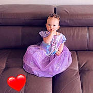 Talya a rejoint le concours — aidez-le/la à gagner de superbes lots ! animated_character, casual, child, couch, curious, cute, dress, furniture, heart_emoji, home, indoor, leather, person, portrait, purple, sitting, smile, thumb_sucking, toddler, young_child
