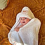 baby, towel, hooded_towel, blanket, infant, cute, blue_eyes, wrapped, texture, soft, smiling, happy, child, person, indoor, cozy, white, brown, skin, expression