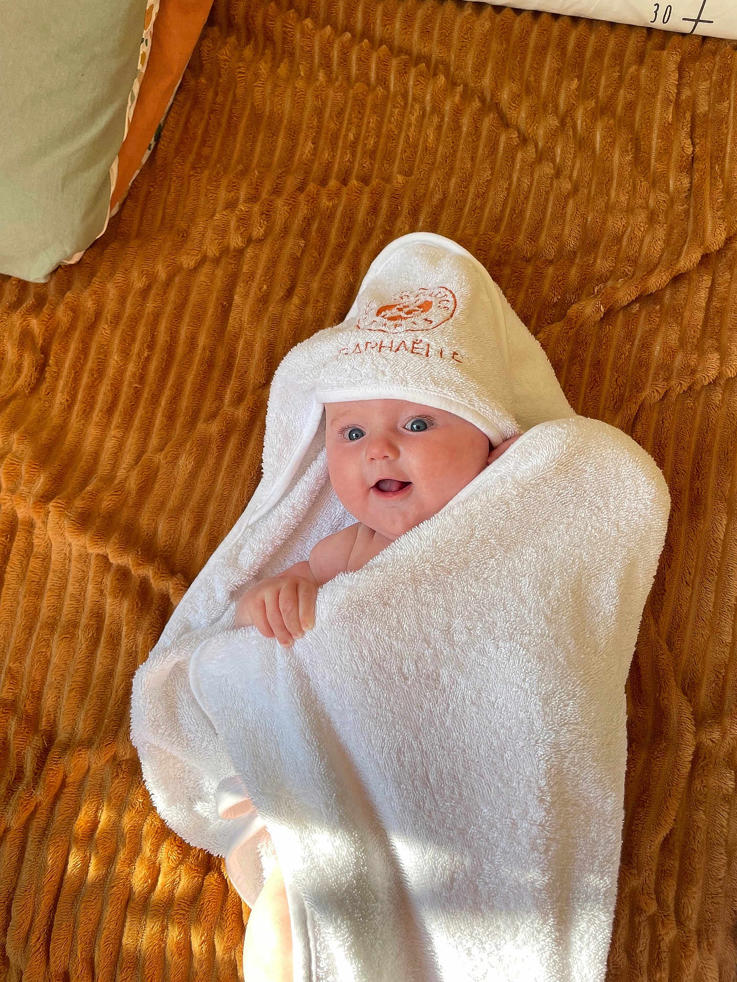 Raphaëlle a rejoint le concours — aidez-le/la à gagner de superbes lots ! baby, towel, hooded_towel, blanket, infant, cute, blue_eyes, wrapped, texture, soft, smiling, happy, child, person, indoor, cozy, white, brown, skin, expression