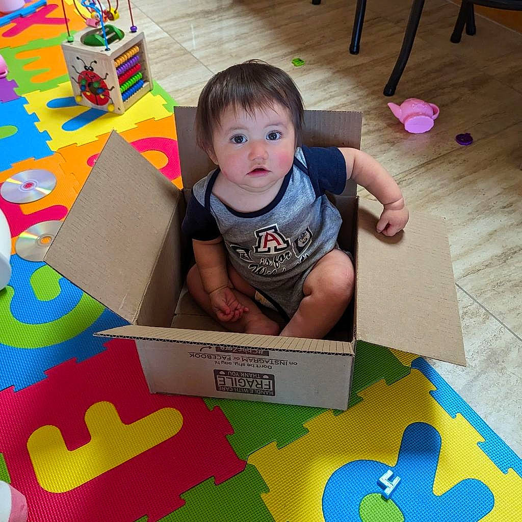 Estrella is registered to the contest to win money with this photo: baby, baby_products, baby_toddler_clothing, child, flooring, foot, fun, happy, hardwood, laminate_flooring, paper_product, person, play, room, sitting, sock, t_shirt, toddler, wood, wood_flooring