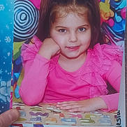 Alesia participe au concours pour gagner de l'argent avec cette photo : child, girl, portrait, pink_clothing, smile, face, hand, table, alphabet_puzzle, colorful_background, abstract_art, reindeer_decoration, holiday_theme, indoor, playful, young_child, long_hair, photograph, seated, happy