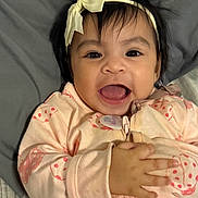 Alanna joined the competition — help win amazing prizes! baby, child, smiling, face, headband, clothing, pink, hand, lying_down, happy, infant, cute, person, portrait, indoors, young_child, apparel, fabric, skin, cheerful