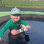 Aarron-Junior joined the competition — help win amazing prizes! blue_sky, casual_clothing, child, daytime, fence, grass, green_jacket, happy, hat, houses, outdoor, person, playground, recreation, sitting, smiling, sneakers, sunny_day, toddler, trampoline