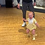 adult, baby, balloons, candid, celebration, child, family, feet, fun, happy, indoor, joy, motion_blur, person, smiling, socks, support, walking, wooden_floor, yellow_outfit