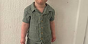 Aarron-Junior is registered to the contest to win money with this photo: button_up, casual, child, cute, feet, floor, green_clothing, happy, head, indoor, person, portrait, shirt, shorts, smiling, sneakers, standing, toddler, white_wall, young_child